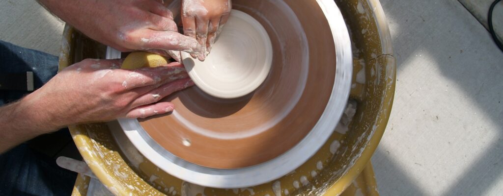 a group of people working on a pottery wheel