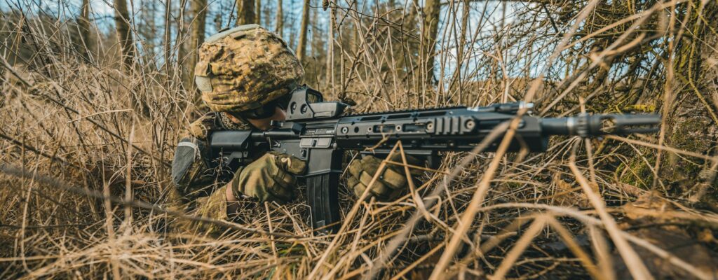 black and brown assault rifle on brown dried leaves